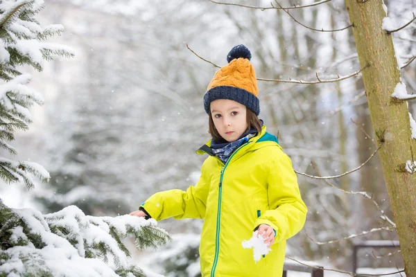 Doux tout-petit garçon, jouant avec la neige sur l'aire de jeux — Photo