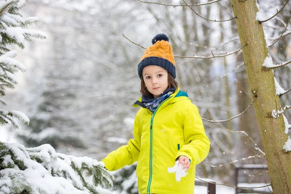 Dolce bambino ragazzo, giocando con la neve sul parco giochi — Foto Stock