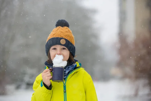 Dolce bambino ragazzo, giocando con la neve sul parco giochi — Foto Stock