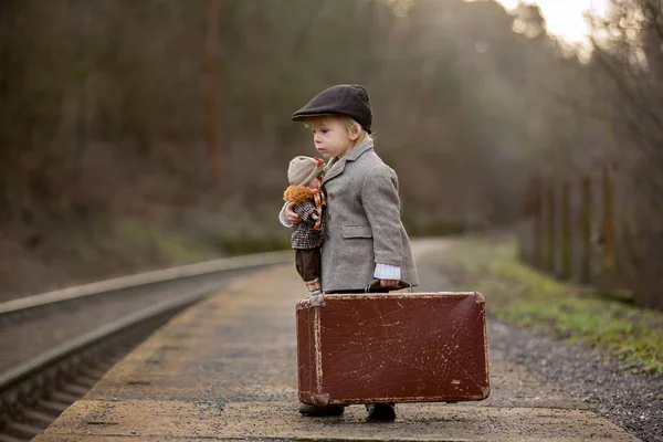 Adorable niño en una estación de tren, esperando el tren con su —  Fotos de Stock