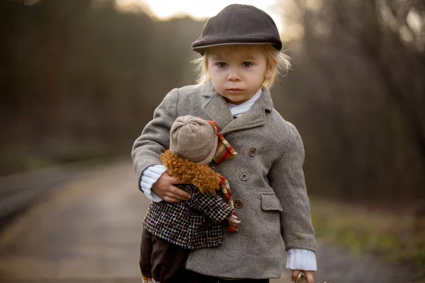 Adorable garçon sur une gare, attendant le train avec su — Photo