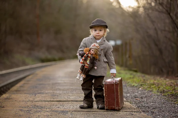 Adorable boy on a railway station, waiting for the train with su — Stock Photo, Image
