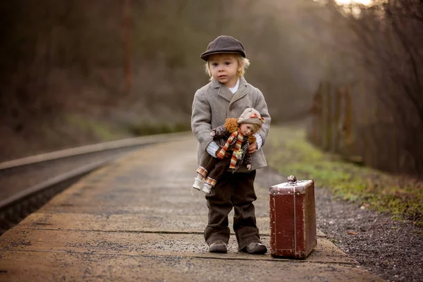 Adorable boy on a railway station, waiting for the train with su — Stock Photo, Image