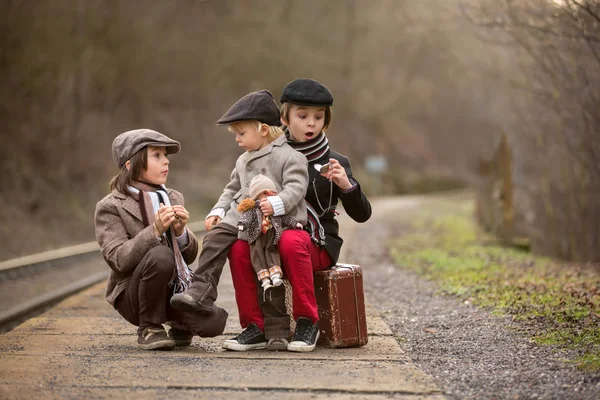 Adorabile ragazzo su una stazione ferroviaria, in attesa del treno con su — Foto Stock