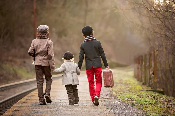 Schattige jongens op een station, wachtend op de trein met v — Stockfoto