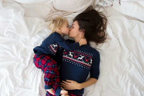 Nice sleepy morning in bed, mom and toddler child, boy, playing,