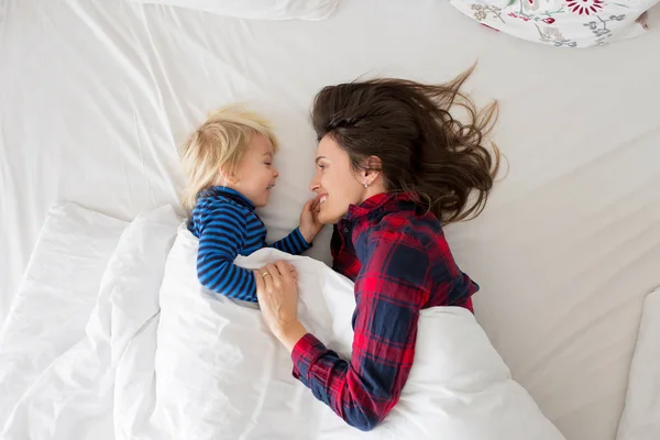 Mooie slaperige ochtend in bed, mam en peuter kind, jongen, spelen, — Stockfoto