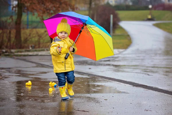 Beautiful funny blonde toddler boy with rubber ducks and colorfu — Stock Photo, Image