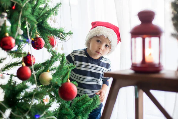 Hermoso niño rubio, decorando el árbol de Navidad con bal —  Fotos de Stock