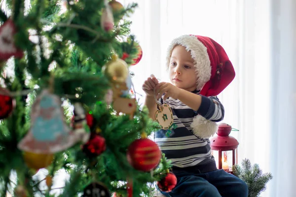Hermoso niño rubio, decorando el árbol de Navidad con bal —  Fotos de Stock
