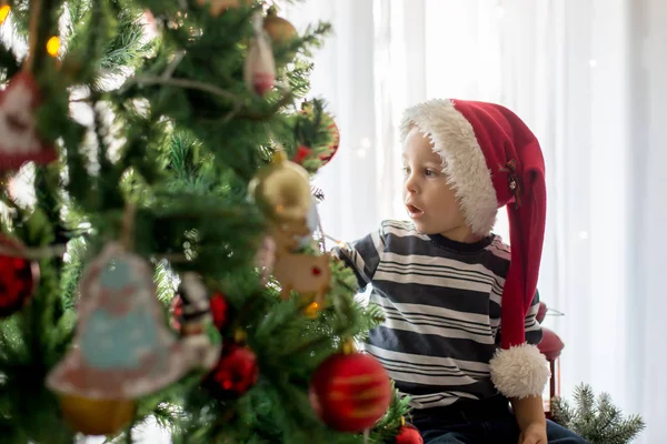 Güzel sarışın çocuk, Noel ağacını balla süslüyor. — Stok fotoğraf