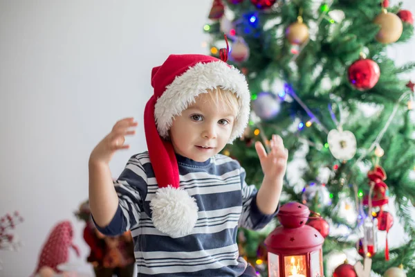 Mooie blonde peuter jongen, versieren kerstboom met bal — Stockfoto