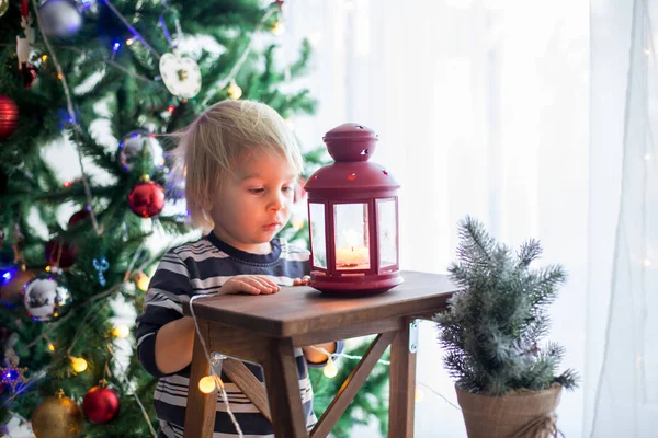 Vacker blond liten pojke, dekorera julgran med bal — Stockfoto