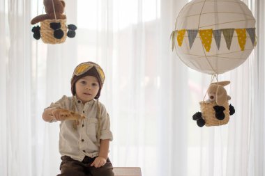Sweet toddler boy, playing with airplane and teddy bear, air bal