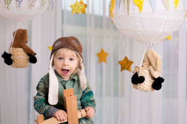 Sweet toddler boy, playing with airplane and teddy bear, air bal