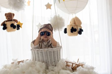 Sweet toddler boy, playing with airplane and teddy bear, air bal