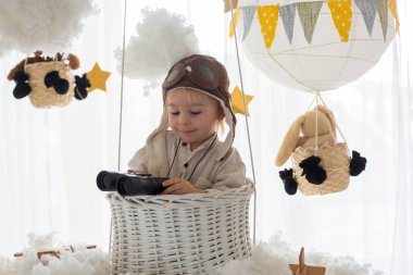 Sweet toddler boy, playing with airplane and teddy bear, air bal