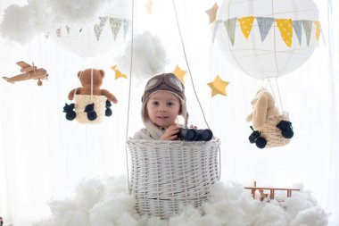 Sweet toddler boy, playing with airplane and teddy bear, air bal