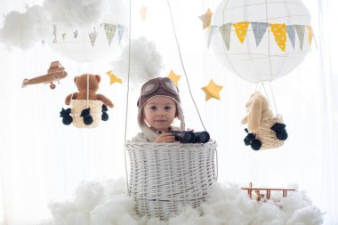 Sweet toddler boy, playing with airplane and teddy bear, air bal