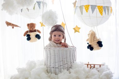 Sweet toddler boy, playing with airplane and teddy bear, air bal