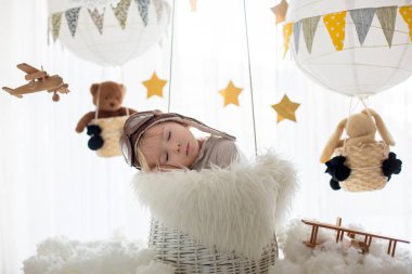 Sweet toddler boy, playing with airplane and teddy bear, air bal