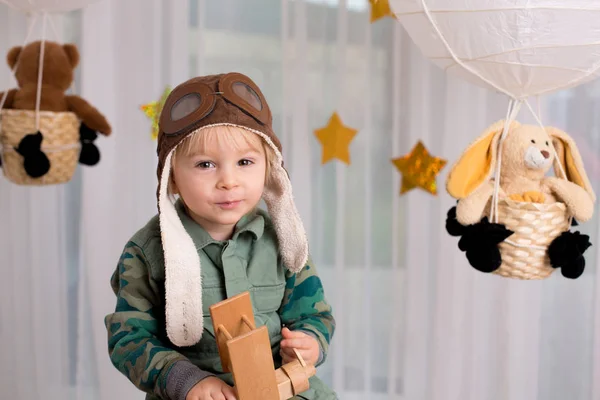 Sweet toddler boy, playing with airplane and teddy bear, air bal — Stockfoto