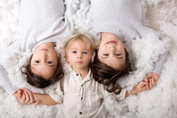 Hermoso retrato de tres hermanos, tumbados en el suelo en —  Fotos de Stock