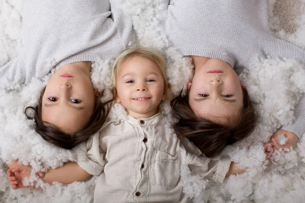 Hermoso retrato de tres hermanos, tumbados en el suelo en —  Fotos de Stock