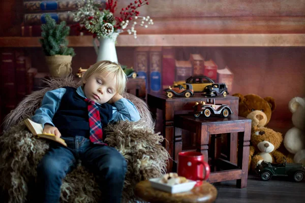 Dulce niño, duérmete en el sofá del bebé mientras lees — Foto de Stock