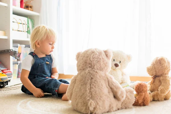 蹒跚学步的小男孩，给他的玩具熊朋友读书。 — 图库照片