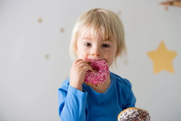 Cute sweet blonde child, playing and eating donuts — Stock Photo, Image