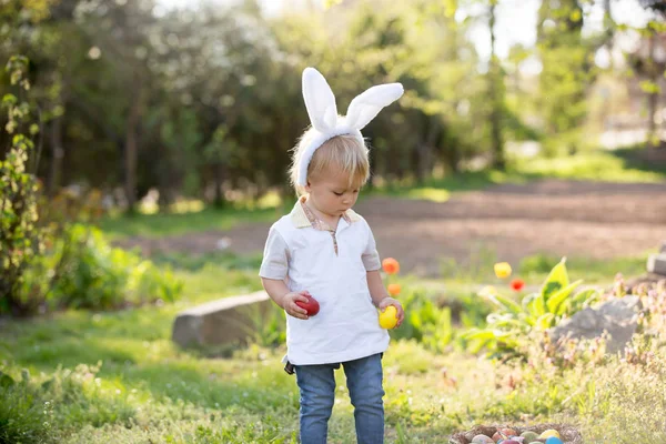 Zoete peuter jongen met bunny oren, eieren jagen voor Pasen, kind — Stockfoto