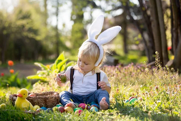 Zoete peuter jongen met bunny oren, eieren jagen voor Pasen, kind — Stockfoto