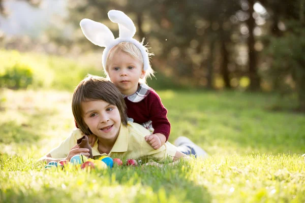 Dolci bambini, fratellini con le orecchie da coniglio, caccia alle uova per Ea — Foto Stock