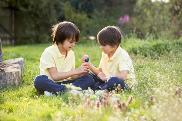 Dulces niños, hermanos con orejas de conejo, cazando huevos para Ea —  Fotos de Stock