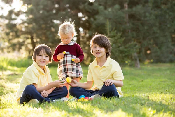 Sweet children, boy brothers with bunny ears, egg hunting for Ea — Stock Photo, Image