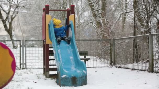甘い幼児の男の子 遊び場で雪と遊ぶ 雪と遊ぶ子供 — ストック動画