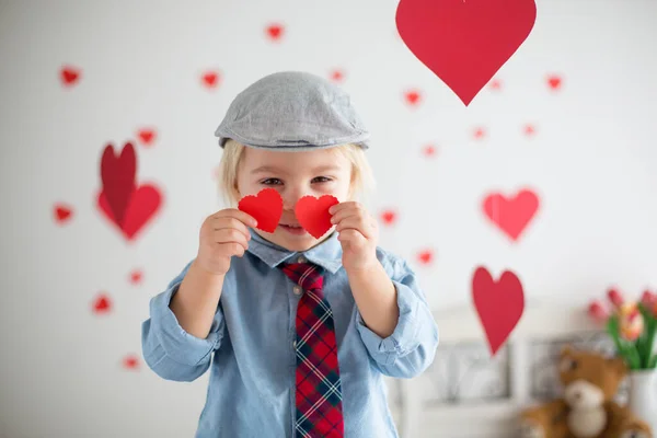 Cute blonde toddler boy, holding heart toy and playing with hear — Stok fotoğraf