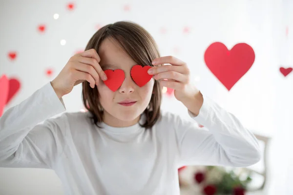 Cute long haired school boy, holding heart box and red roses and — Stok fotoğraf