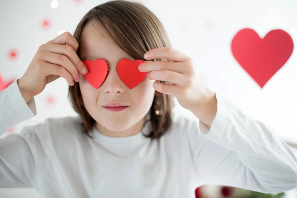 Bonito menino da escola de cabelos longos, segurando caixa de coração e rosas vermelhas e — Fotografia de Stock