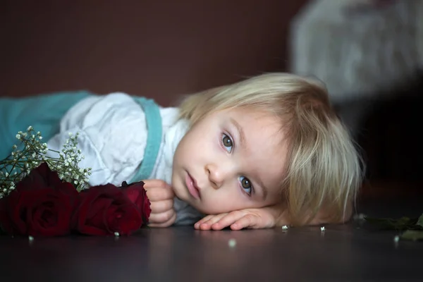 Beautiful toddler boy, holding red roses for mother's day — ストック写真