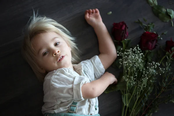 Menino da criança bonita, segurando rosas vermelhas para o dia da mãe — Fotografia de Stock