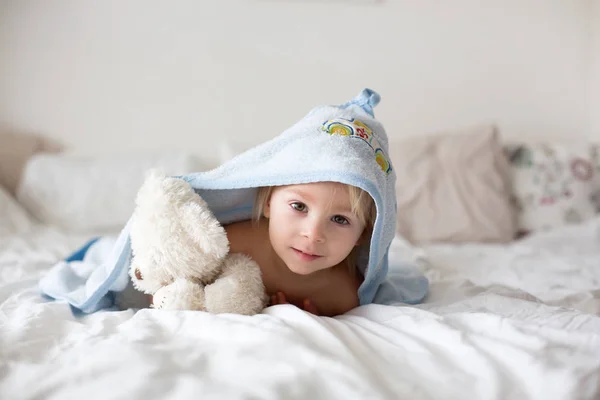 Χαριτωμένο Μικρό Ξανθό Αγοράκι Χαλαρώνοντας Στο Κρεβάτι Μετά Μπάνιο Χαμογελώντας — Φωτογραφία Αρχείου