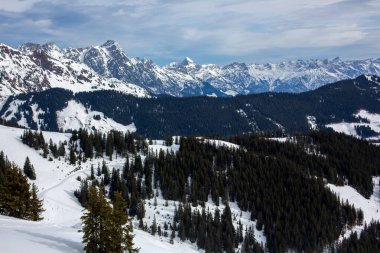 Güneşli bir günde, kış kayak merkezinde manzara, kayak yamaçlarında karlı bir kış günü