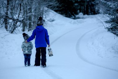 Karda oyuncak ayıyla oynayan tatlı çocuk, kış vakti. Küçük çocuk karlı bir günde oyuncaklarla oynuyor.