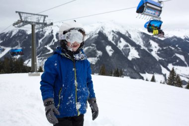 Aile, güneşli bir günde kayak merkezinde kayak yapmak, manzaranın tadını çıkarmak.
