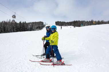 Çocuğum, güneşli bir günde kış kayak merkezinde kayak yapmak, manzaranın tadını çıkarmak