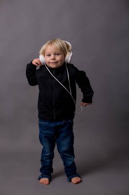 Tatlı çocuk, siyah kazaklı çocuk, müzik dinliyor, izole edilmiş arka plan