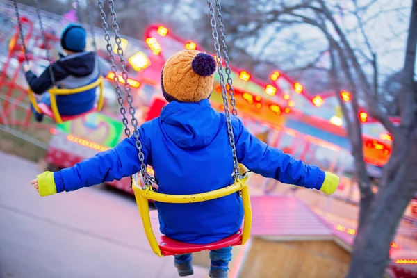 Criança Bonito Menino Montando Cadeia Swing Carrossel Pôr Sol Borrão — Fotografia de Stock