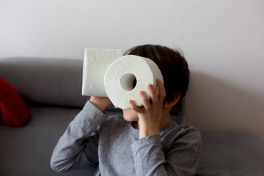 Çocuk, tuvalet kağıdıyla oynuyor.